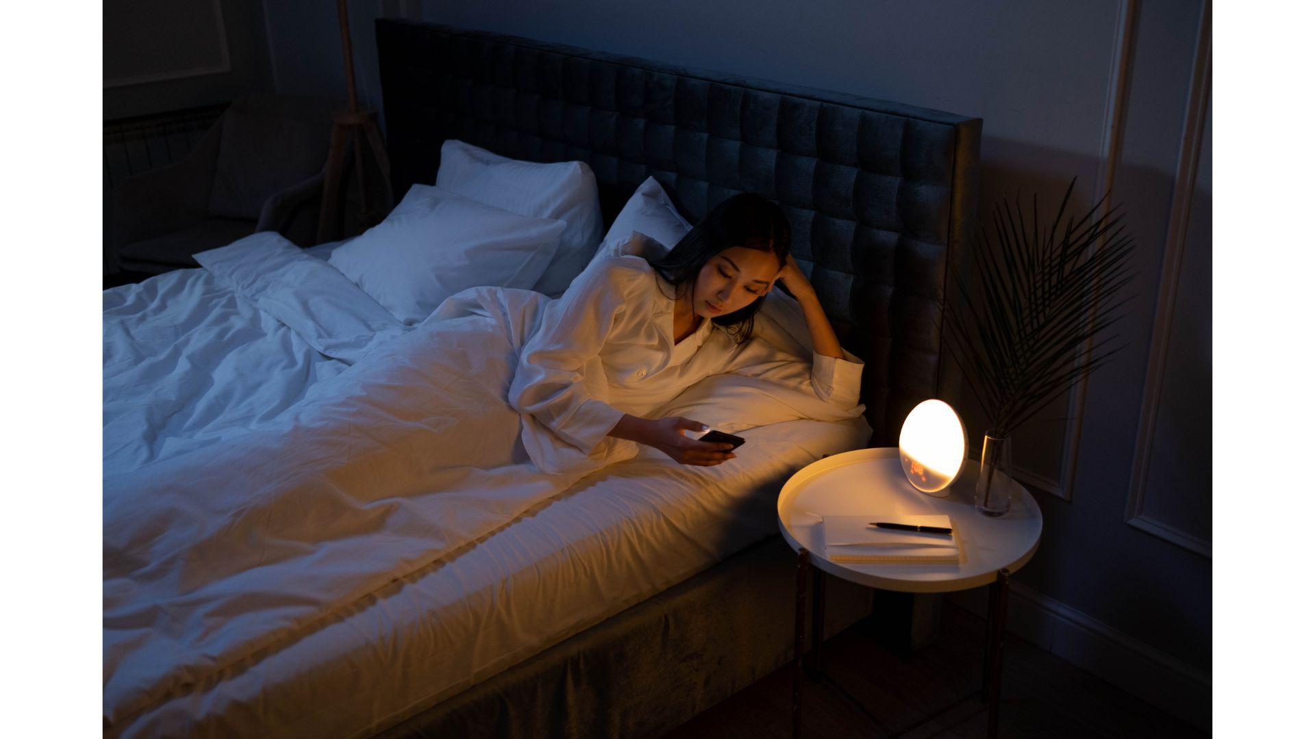 Checking the time A picture of A female checking the time at night, showing that hypnotherapy can help with insomnia.